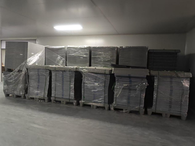 Aerial wide-angle view of a large industrial semiconductor material warehouse facility in Haidong, Qinghai, showing extensive storage areas and logistics zones.